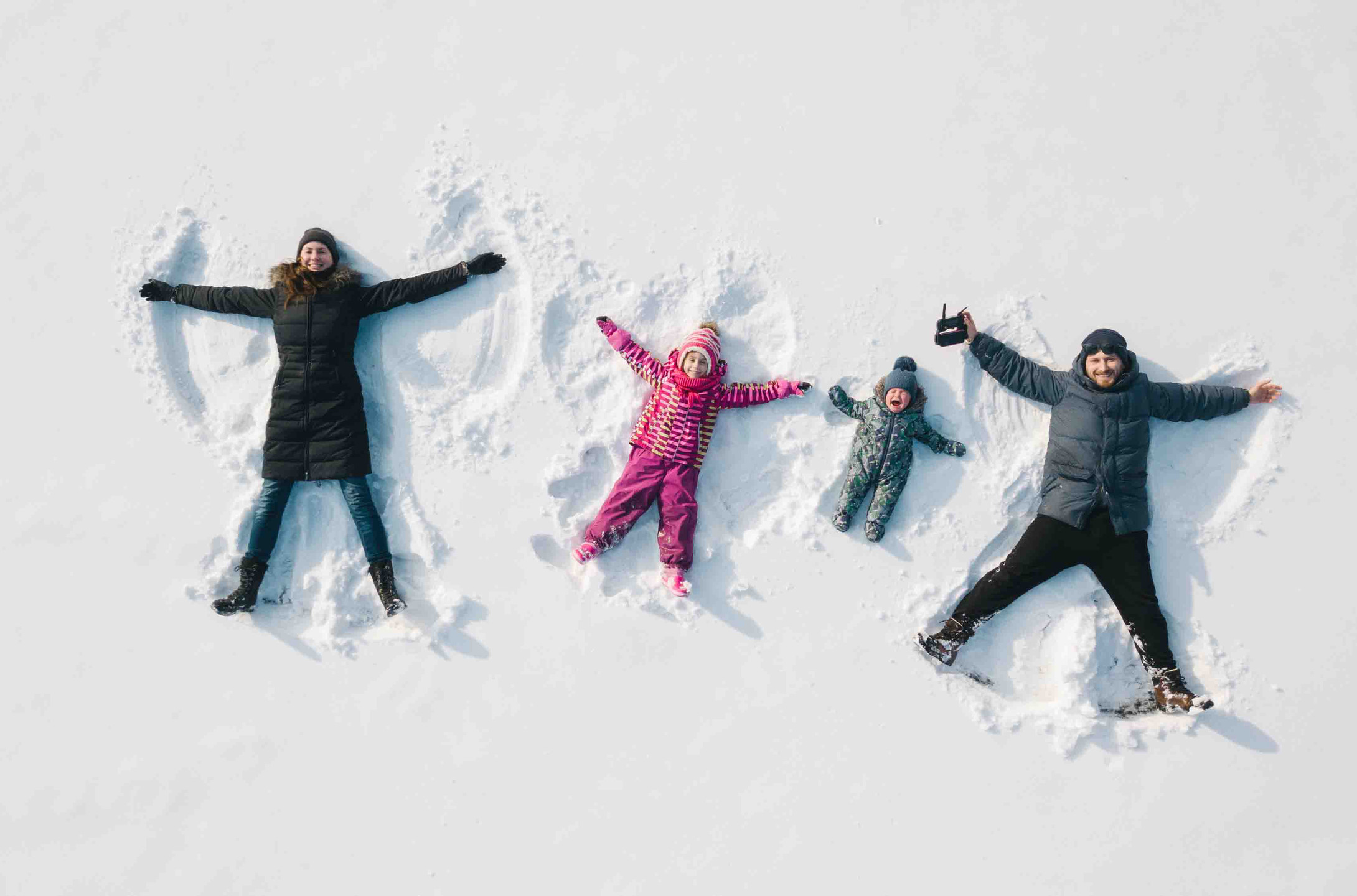 Family making snow angels